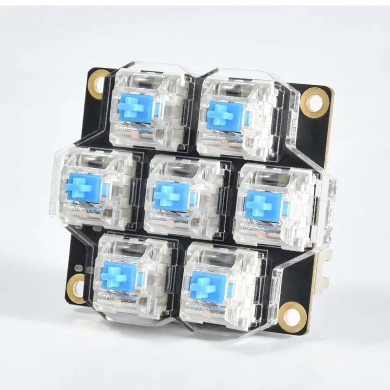 BigTreeTech HBB/HBB Fe: Black PCB with seven blue mechanical keyboard switches, perfect for custom builds.