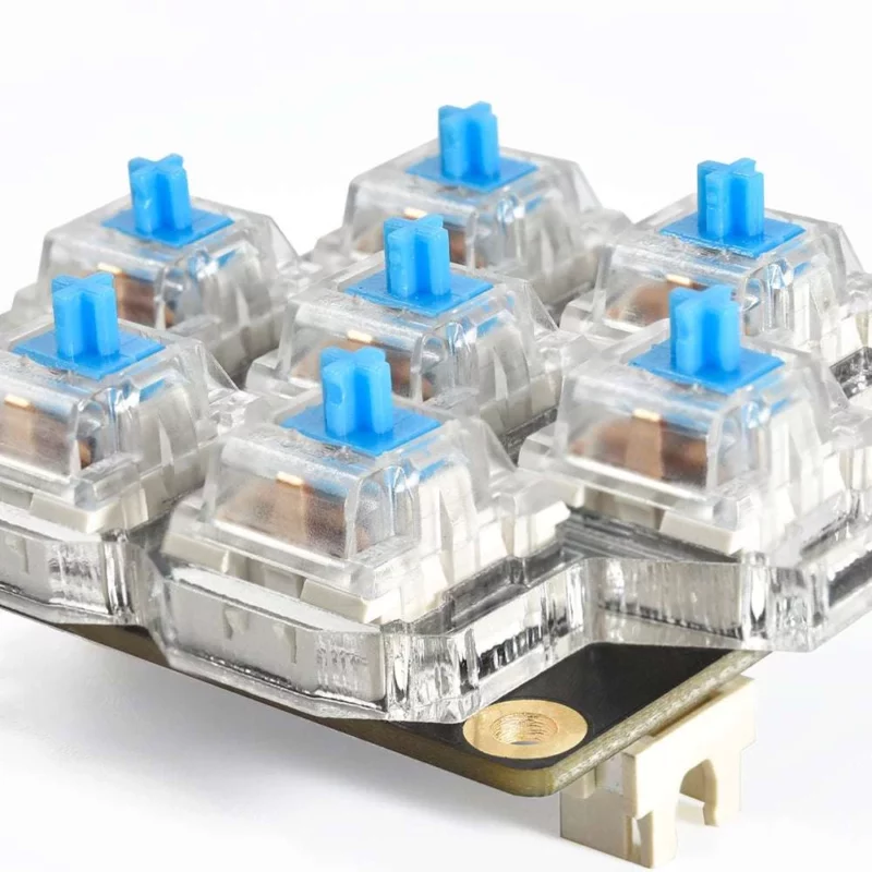 BigTreeTech HBB/HBB Fe mechanical keyboard switches with blue stems, transparent housing, and gold accents
