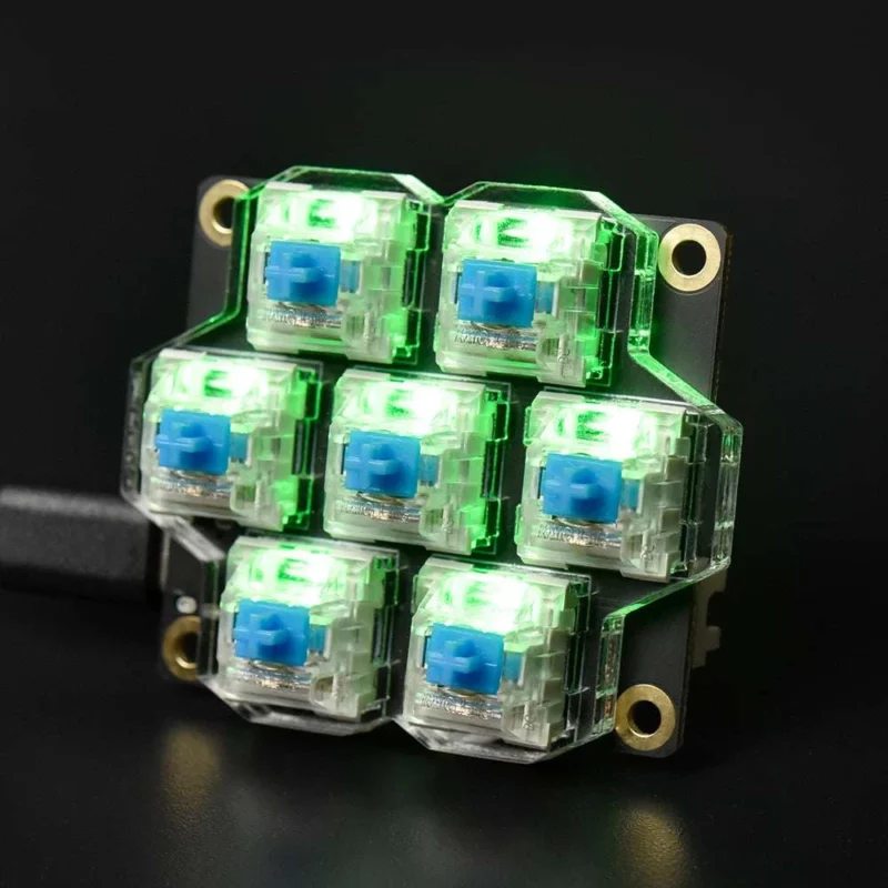 BigTreeTech HBB/HBB Fe: Seven mechanical keyboard switches on a black PCB, lit up green. Includes USB cable.
