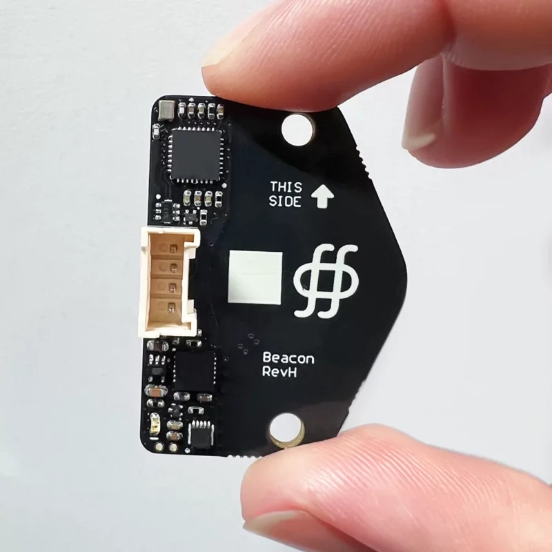 Beacon 3D Sensor Surface Scanner REV H held, showing white markings, connector, and "THIS SIDE" indicator.