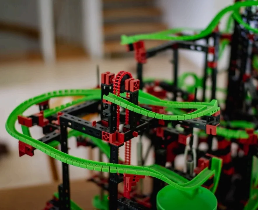 Close-up of a complex, colorful construction made of black, red, and green interlocking blocks.